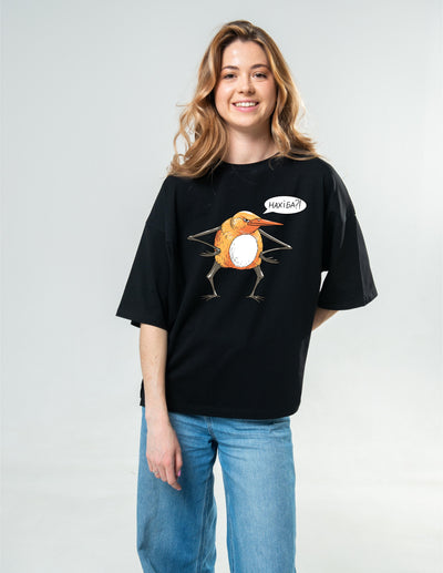 Woman wearing a black t-shirt with a graphic design on a plain background
